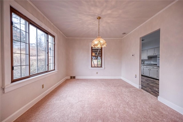 unfurnished dining area with crown molding, carpet floors, and an inviting chandelier