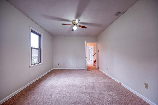 carpeted spare room featuring ceiling fan