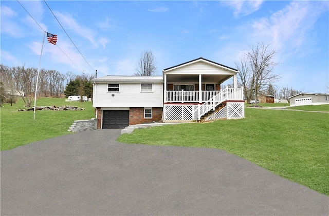 view of front of property with a porch, a garage, and a front lawn