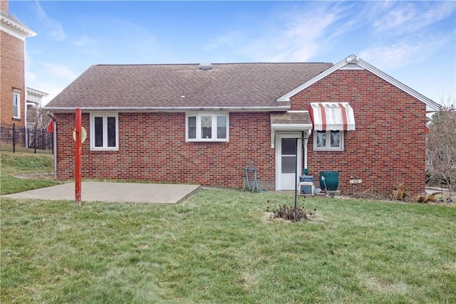 rear view of property with a yard and a patio area