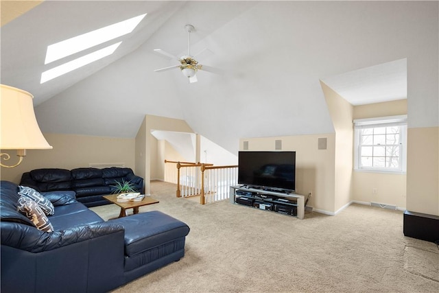 carpeted living room featuring vaulted ceiling with skylight and ceiling fan