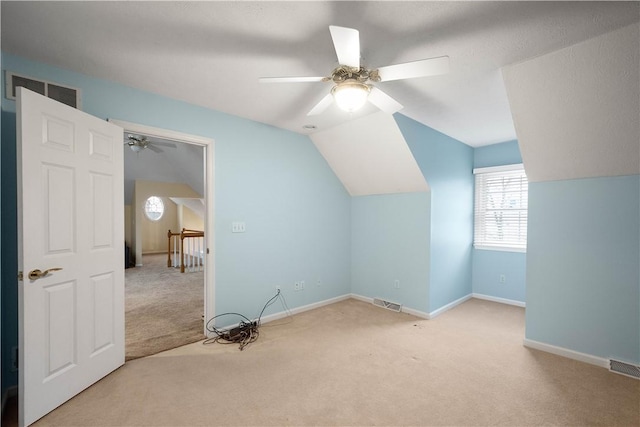 additional living space with lofted ceiling, light carpet, and ceiling fan