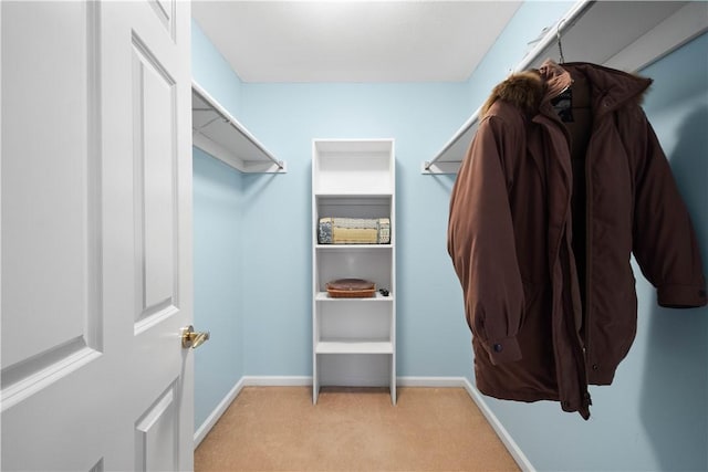 walk in closet featuring light carpet