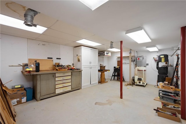 basement featuring a drop ceiling and a workshop area