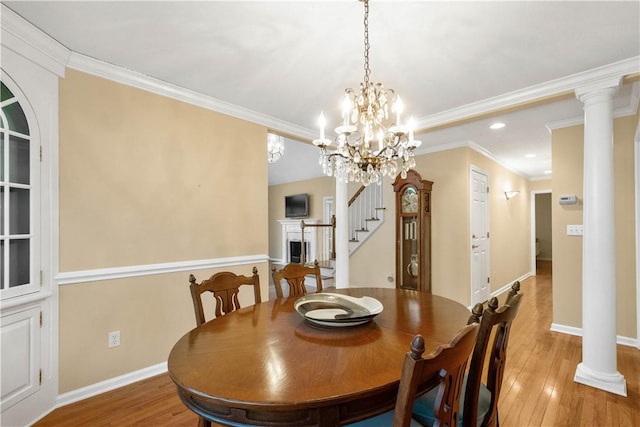 dining area featuring crown molding, light wood-type flooring, and ornate columns