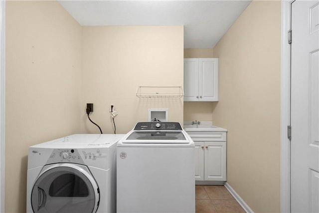 laundry room featuring cabinets, sink, light tile patterned floors, and independent washer and dryer