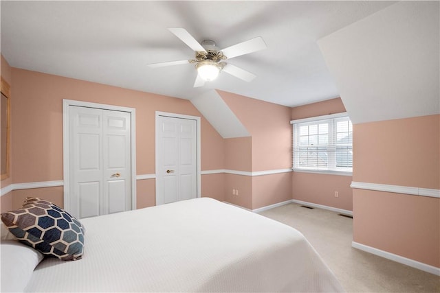 carpeted bedroom with ceiling fan and vaulted ceiling