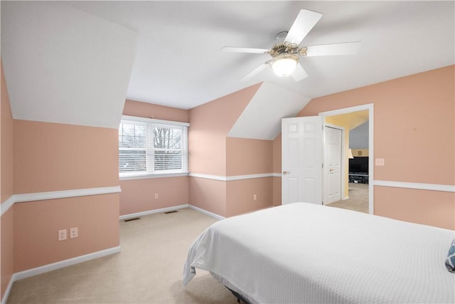 bedroom featuring ceiling fan, vaulted ceiling, and light carpet