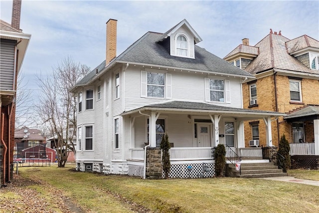 view of front of property featuring a porch, a front yard, a trampoline, and cooling unit