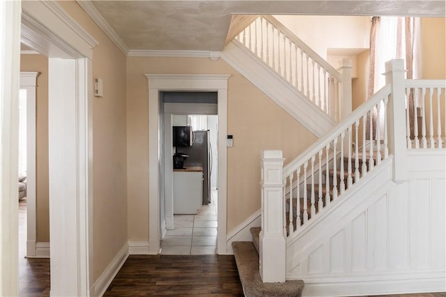 stairs with wood-type flooring and ornamental molding