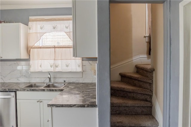 kitchen featuring sink, backsplash, stainless steel dishwasher, and white cabinets