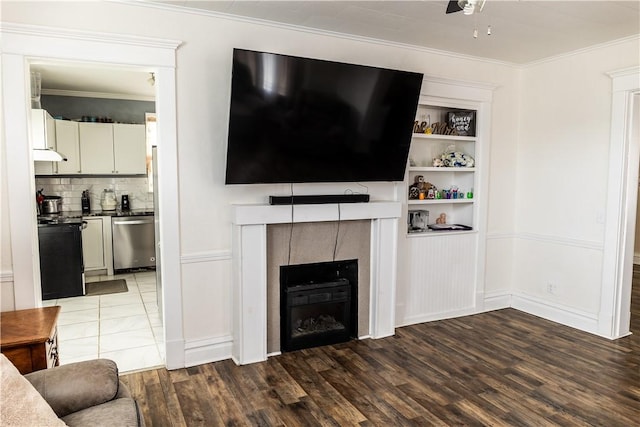 living room featuring ornamental molding, hardwood / wood-style floors, and a tile fireplace