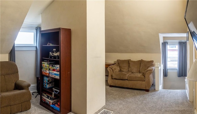 interior space with lofted ceiling, light carpet, and a healthy amount of sunlight