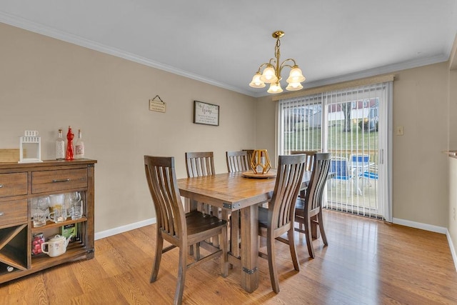 dining area with crown molding, a chandelier, and light hardwood / wood-style floors