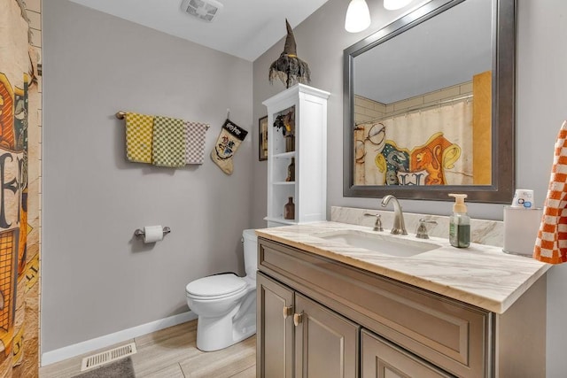 bathroom featuring vanity, hardwood / wood-style floors, and toilet