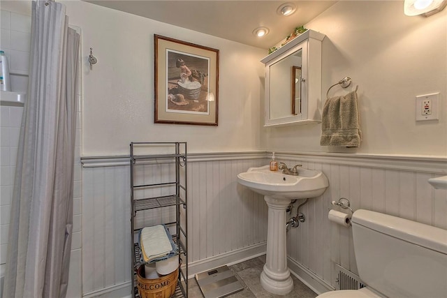 bathroom featuring toilet and a shower with shower curtain