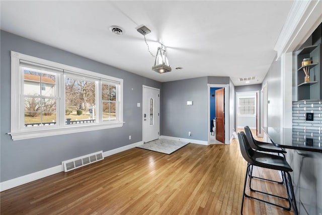 interior space featuring hardwood / wood-style flooring, a kitchen bar, and tasteful backsplash