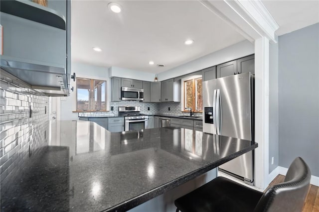 kitchen featuring appliances with stainless steel finishes, a breakfast bar, and plenty of natural light