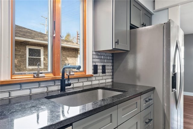 kitchen featuring gray cabinets, sink, dark stone countertops, backsplash, and dark hardwood / wood-style flooring