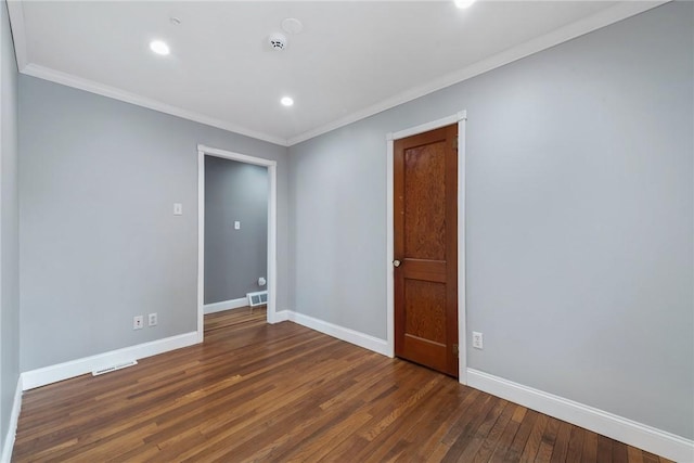 empty room featuring ornamental molding and dark hardwood / wood-style flooring