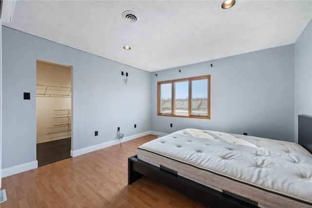 bedroom featuring hardwood / wood-style floors and a textured ceiling