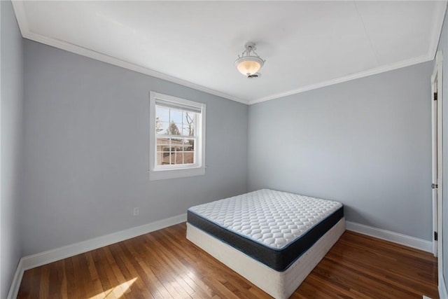 bedroom featuring ornamental molding and dark hardwood / wood-style flooring