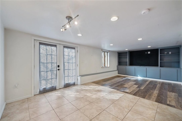 tiled empty room with built in features and french doors