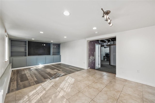 unfurnished room with built in shelves and light tile patterned floors