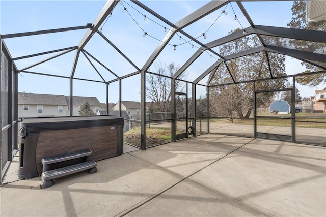 view of patio featuring a hot tub and a lanai