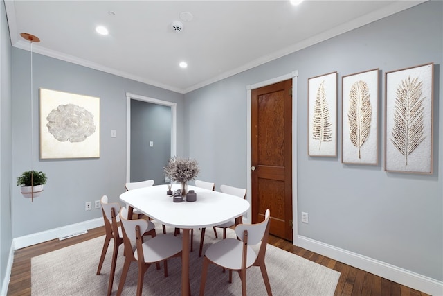 dining space featuring ornamental molding and dark hardwood / wood-style floors