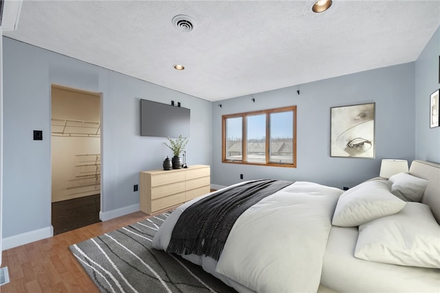 bedroom featuring hardwood / wood-style floors and a textured ceiling