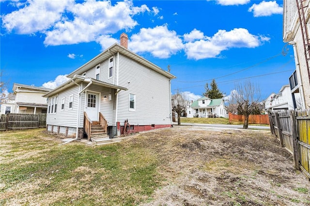 rear view of house featuring a lawn