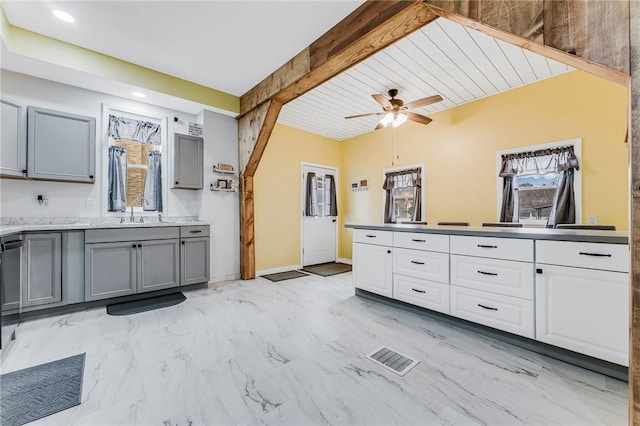 interior space with beamed ceiling, vanity, and ceiling fan