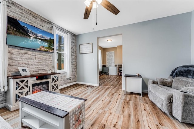 living room featuring ceiling fan and light hardwood / wood-style floors