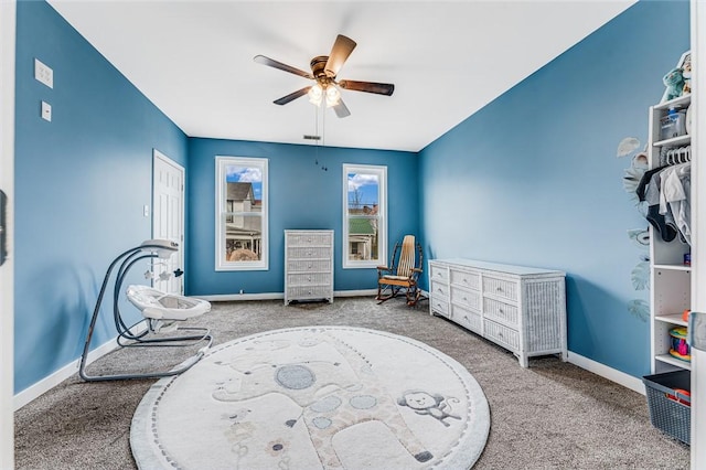 sitting room with ceiling fan and carpet