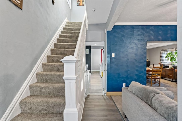 stairs with beamed ceiling and wood-type flooring