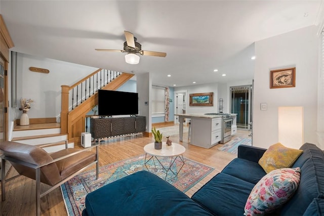 living room with ceiling fan and light hardwood / wood-style flooring