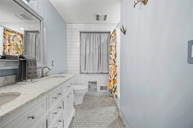 bathroom with tile patterned flooring, vanity, tile walls, and toilet