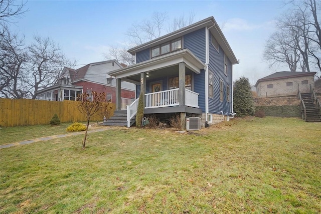 view of front of home with cooling unit, covered porch, and a front lawn