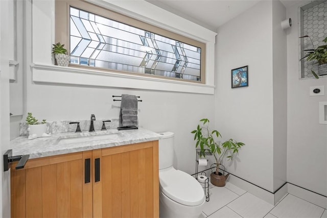 bathroom with vanity, a healthy amount of sunlight, tile patterned floors, and toilet