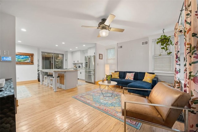 living room with ceiling fan and light wood-type flooring