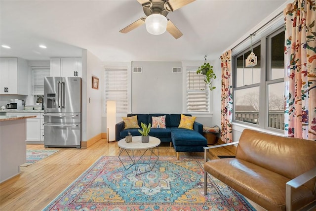 living room featuring ceiling fan and light hardwood / wood-style flooring