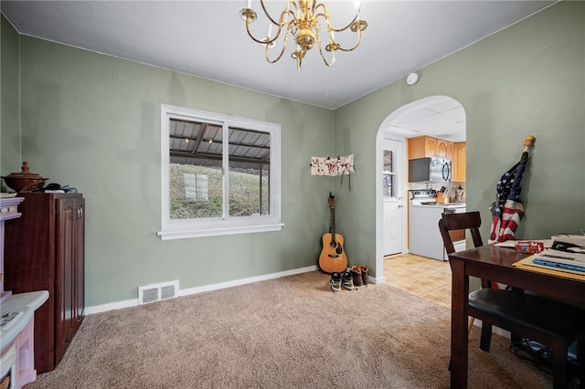 carpeted dining room with a chandelier