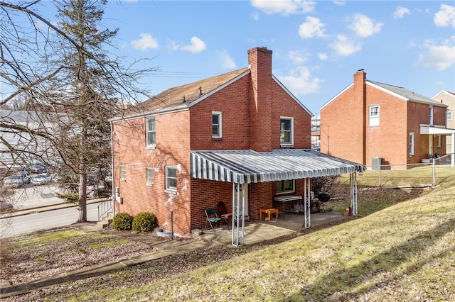 rear view of house featuring a patio area and a lawn