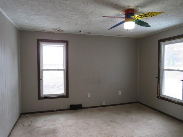 carpeted empty room featuring ceiling fan and a textured ceiling