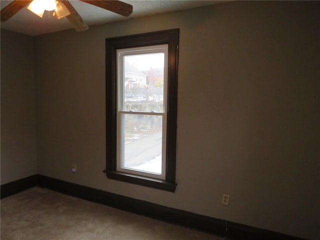 unfurnished room featuring ceiling fan and baseboards