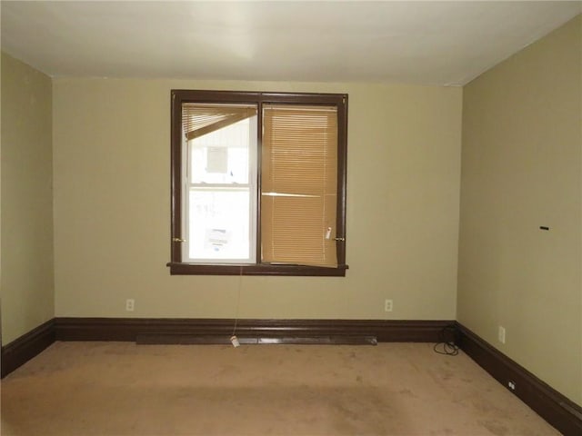 carpeted empty room featuring baseboards