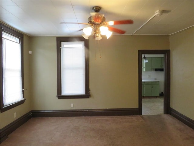 empty room featuring carpet flooring, ceiling fan, and baseboards