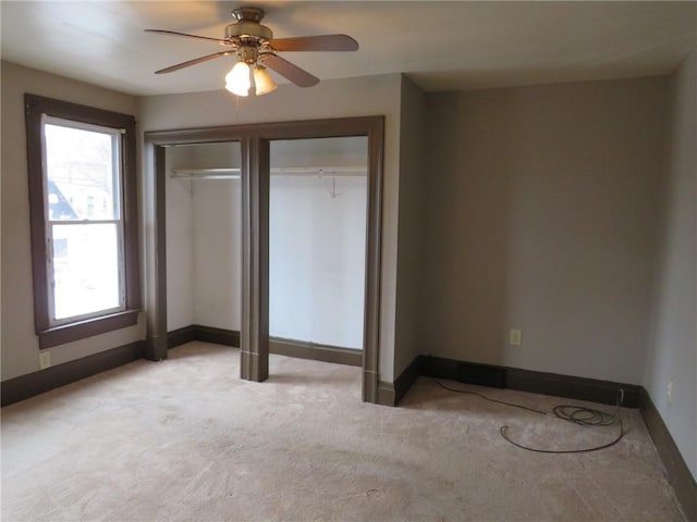 unfurnished bedroom with light carpet, ceiling fan, and a closet