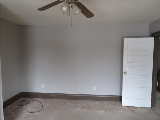 spare room featuring a ceiling fan, unfinished concrete flooring, and baseboards